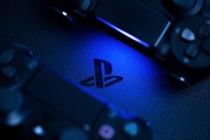 playstation logo in dark background with two black controllers playstation logo in dark background with two black controllers
